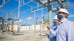 CPS Energy’s Vice President of Grid Transformation & Engineering, Richard Medina, front, and Chief Security, Safety & Gas Solutions Officer Fred Bonewell evaluate security measures at an area substation.