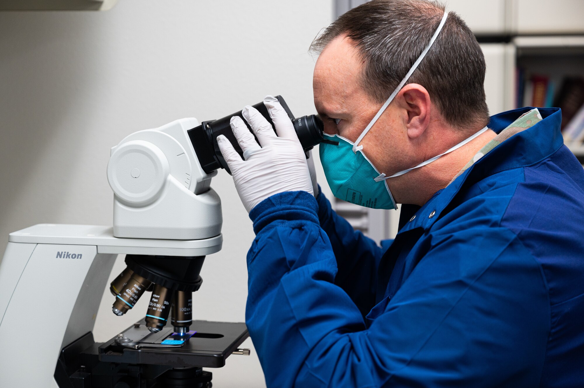 A photo of the 47th Flying Training Wing commander, Col. Craig Prather, looking into a microscope