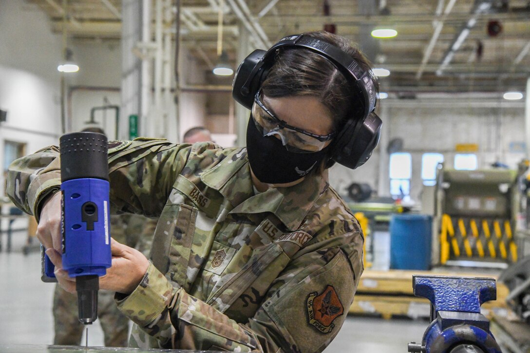 Chief Master Sergeant of the Air Force JoAnne S. Bass learns how to use an air compressed nail gun during her visit to Dover Air Force Base, Delaware, Jan. 8, 2021. The office of the Chief Master Sergeant of the Air Force represents the highest enlisted level of leadership, provides direction for the enlisted corps and represents their interests to the American public and all levels of government. (U.S. Air Force photo by Airman 1st Class Stephani Barge)