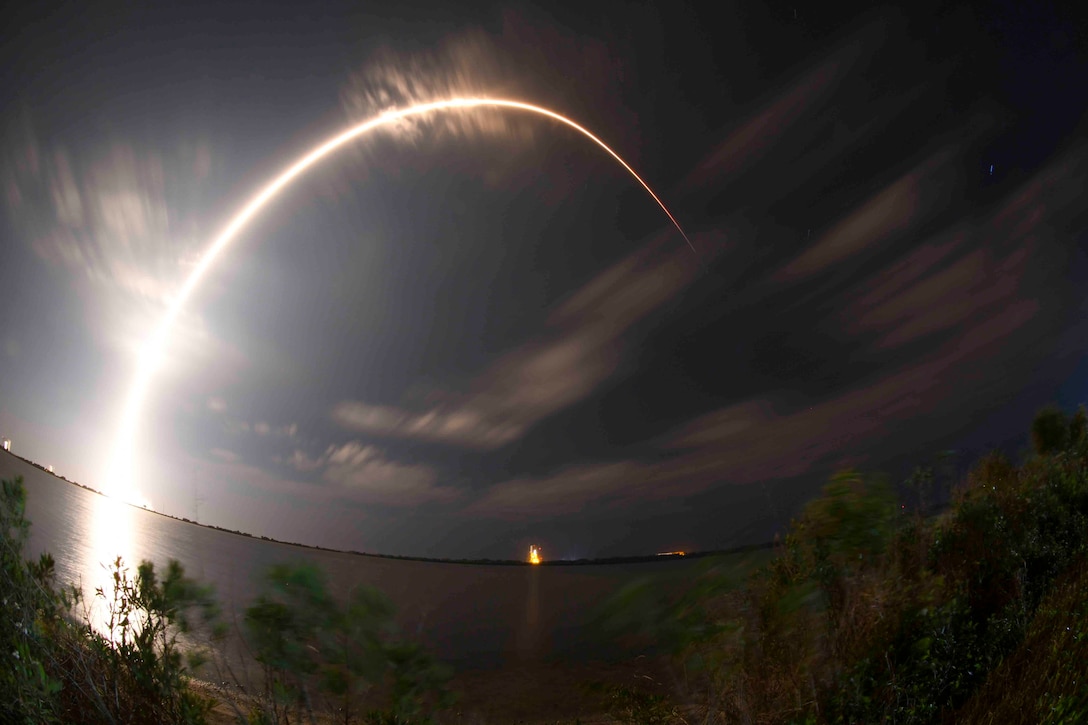 A rocket streams across the sky.