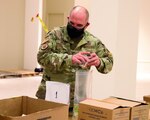 U.S. Air Force Senior Master Sgt. Timothy Aplin, assigned to the Michigan National Guard’s COVID-19 response task force, is working at the Greater Lansing Food Bank, Lansing, Michigan, Jan. 6, 2021. He is one of five service members assigned to the food bank helping to distribute food to schoolchildren.