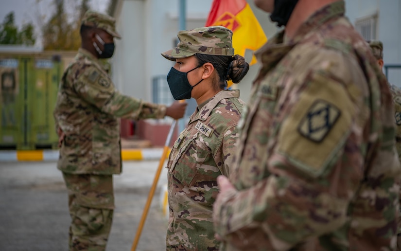 Sgt. Brandy Lopez, nearest, an Information Technology (IT) Specialist assigned to 75th Field Artillery Brigade, stands at the position of attention waiting to be promoted to the rank of sergeant while deployed to the Middle East on December 28, 2020. For the past nine months, Lopez had provided countless hours of IT support and troubleshooting to every Diamond Brigade Soldier deployed to the Middle East and was selected as the only Specialist to be promoted through Battle Field Promotion within Area Support Group - Jordan. (U.S. Army photo by Sgt. Dustin D. Biven / 75th Field Artillery Brigade)