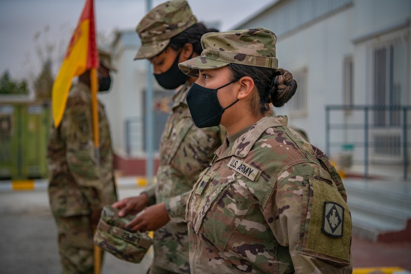 Sgt. Brandy Lopez, nearest, an Information Technology (IT) Specialist assigned to 75th Field Artillery Brigade, stands at the position of attention waiting to be promoted to the rank of sergeant while deployed to the Middle East on December 28, 2020. For the past nine months, Lopez had provided countless hours of IT support and troubleshooting to every Diamond Brigade Soldier deployed to the Middle East and was selected as the only Specialist to be promoted through Battle Field Promotion within Area Support Group - Jordan. (U.S. Army photo by Sgt. Dustin D. Biven / 75th Field Artillery Brigade)