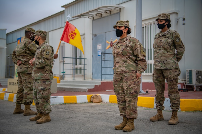 1st Sgt. Thomas Hance, left, the senior enlisted advisor for Headquarters and Headquarters Battery, 75th Field Artillery Brigade, Fort Sill, OK, speaks on the merits of Sgt. Brandy Lopez, center right, an Information Technology (IT) Specialist assigned to 75th Field Artillery Brigade, prior to her being promoted to the rank of sergeant while deployed to the Middle East on December 28, 2020. For the past nine months, Lopez had provided countless hours of IT support and troubleshooting to every Diamond Brigade Soldier deployed to the Middle East and was selected as the only Specialist to be promoted through Battle Field Promotion within Area Support Group - Jordan. (U.S. Army photo by Sgt. Dustin D. Biven / 75th Field Artillery Brigade)