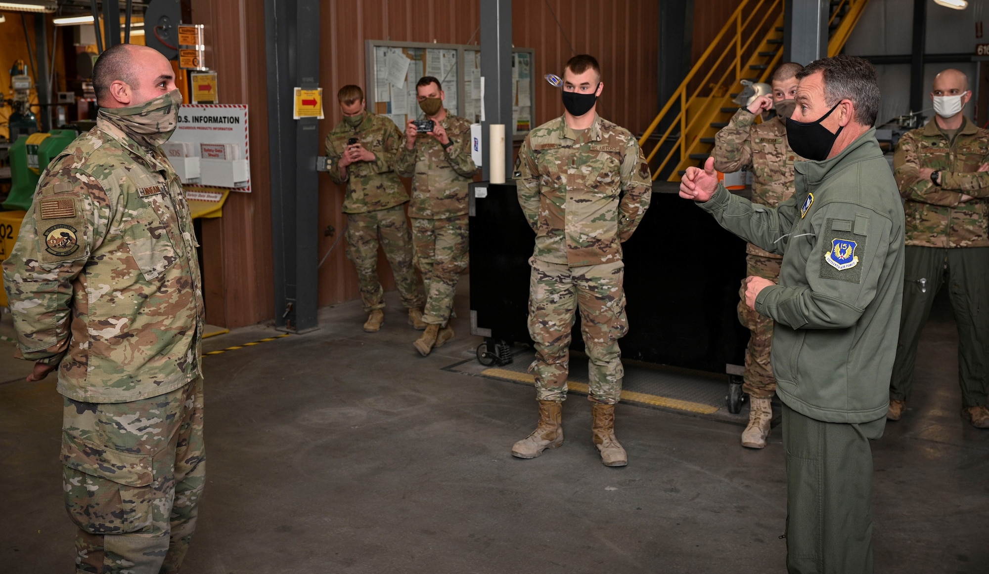 Maj. Gen. Franks flips a coin to an Airman.