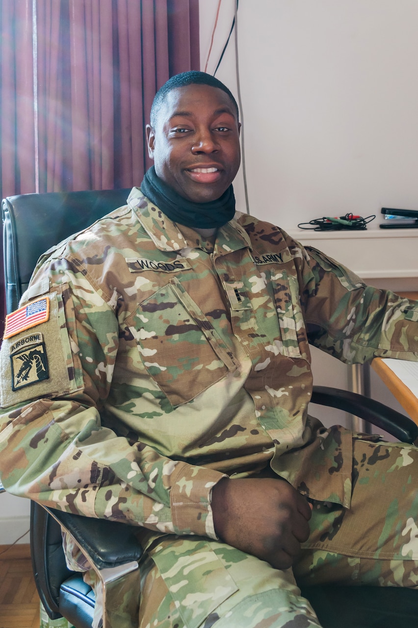 A seated soldier smiles for the camera.