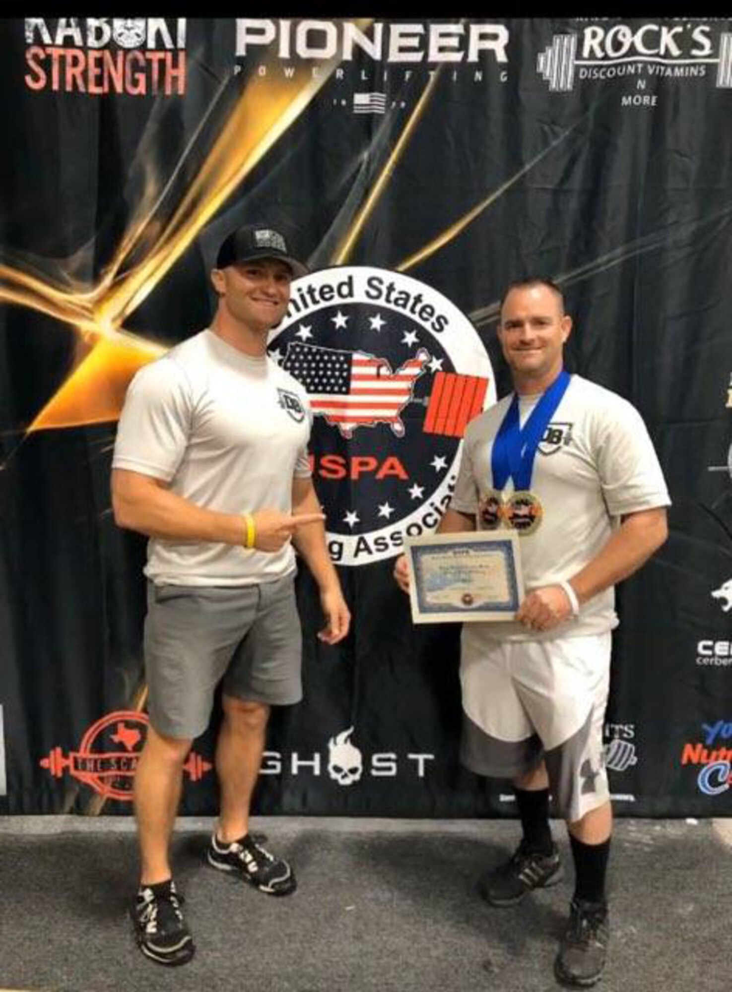 Master Sgt. Daniel Bedford (right), Air Force Recruiting Service National Events program manager and Senior Master Sgt. Michael Lear, AFRS Strategic Marketing Division superintendent, show off Bedford’s two gold medals he won at the USPA (United State Powerlifting Association) 2020 Texas State Bench Press Championship and the USPA Military National Bench Press Championship.