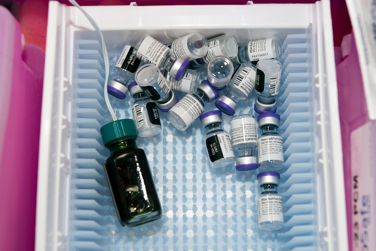 An assortment of vaccine bottles sit in a basket.