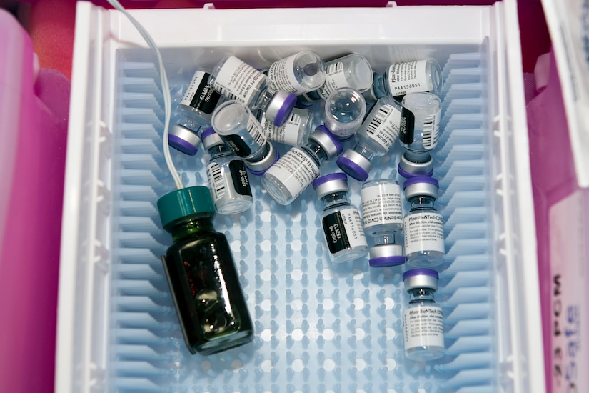 An assortment of vaccine bottles sit in a basket.