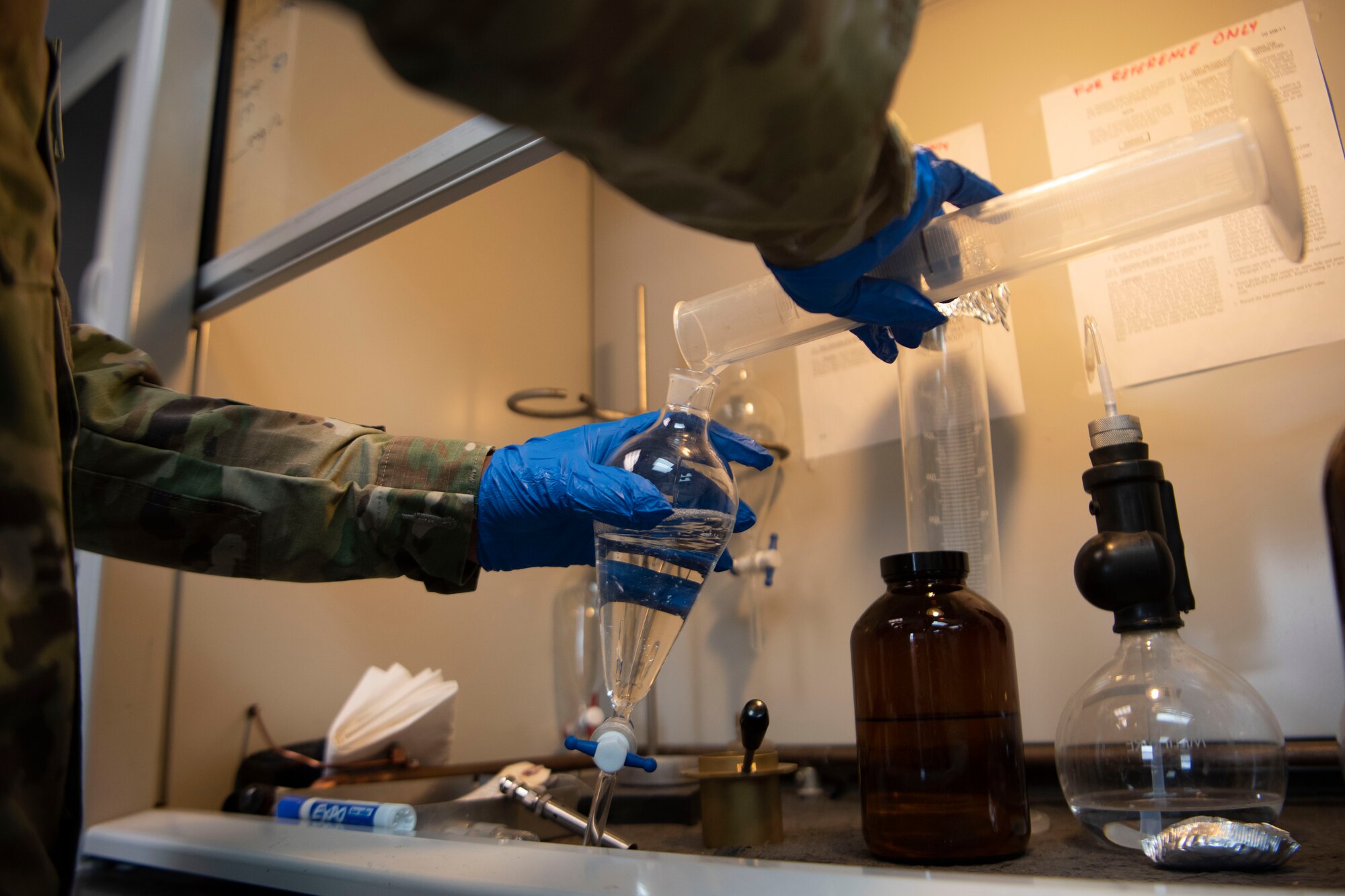 An Airman mixes fuel with another solution to check its quality