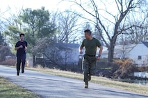 U.S. Marine Capt. David Chang, right, the operations officer of Recruiting Station (RS) Cleveland motivates a poolee with RS Cleveland, during an initial strength test (IST) in Akron, Ohio, Jan. 9, 2021. The IST is a standard test designed to gauge the physical fitness of poolees, which consists of a mile and a half run, crunches and pull-ups. (U.S. Marine Corps photo by Cpl. Nello Miele)