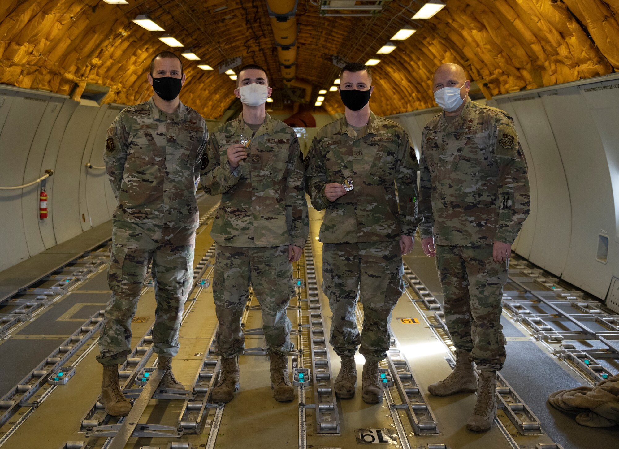 U.S. Air Force Col. Zachery Jiron, left, 60th Air Mobility Wing vice commander, and Chief Master Sgt. Robert Schultz, right, 60th AMW command chief, recognize Senior Airman Schuyler Dolton, second left, 660th AMXS Instrument flight control system journeyman, and Senior Airman Nikolas McEssey, 660th Aerial Maintenance Squadron flying crew chief, as star performers during Leadership Rounds Jan. 8, 2021, at Travis Air Force Base, California. The Leadership Rounds program provides 60th AMW leadership an opportunity to interact with Airmen and receive a detailed view of each mission performed at Travis AFB. (U.S. Air Force photo by Senior Airman Cameron Otte)