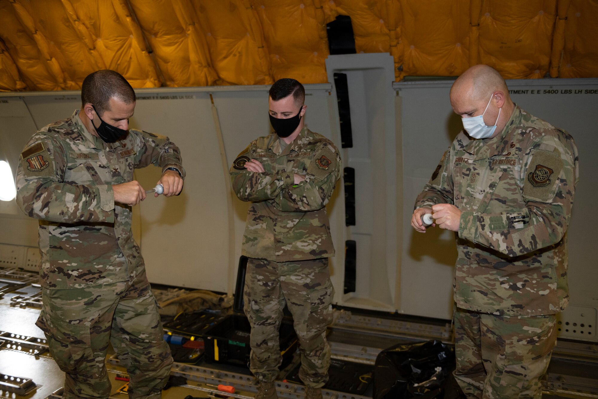 U.S. Air Force Senior Airman Nikolas McEssey, middle, 660th Aerial Maintenance Squadron flying crew chief, instructs Col. Zachery Jiron, left, 60th Air Mobility Wing vice commander, and Chief Master Sgt. Robert Schultz, 60th AMW command chief, on how to mix sealant during Leadership Rounds Jan. 8, 2021, at Travis Air Force Base, California. The Leadership Rounds program provides 60th AMW leadership an opportunity to interact with Airmen and receive a detailed view of each mission performed at Travis AFB. (U.S. Air Force photo by Senior Airman Cameron Otte)