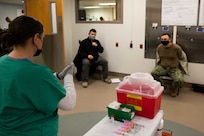JOINT BASE LANGLEY-EUSTIS (January 11, 2021) Joint Task Force Civil Support Surgeon General Navy Capt. Dirk Warren, and Dustin Bryson, of the command’s J6 directorate, receive a brief at the McDonald Army Health Center before receiving the COVID-19 vaccination at McDonald Army Health Center.