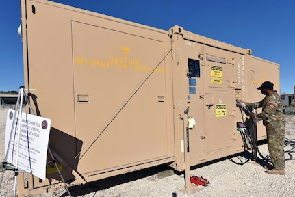 Sgt. 1st Class Elijah Williamson, a test and evaluation officer at the AMEDD Board, checks cabling on the outside of the new deployable CT scanner that is housed inside an expandable ISO container that, once opened, allows for increased interior space for Army 61R diagnostic radiologists and 68P radiology specialists patient care.