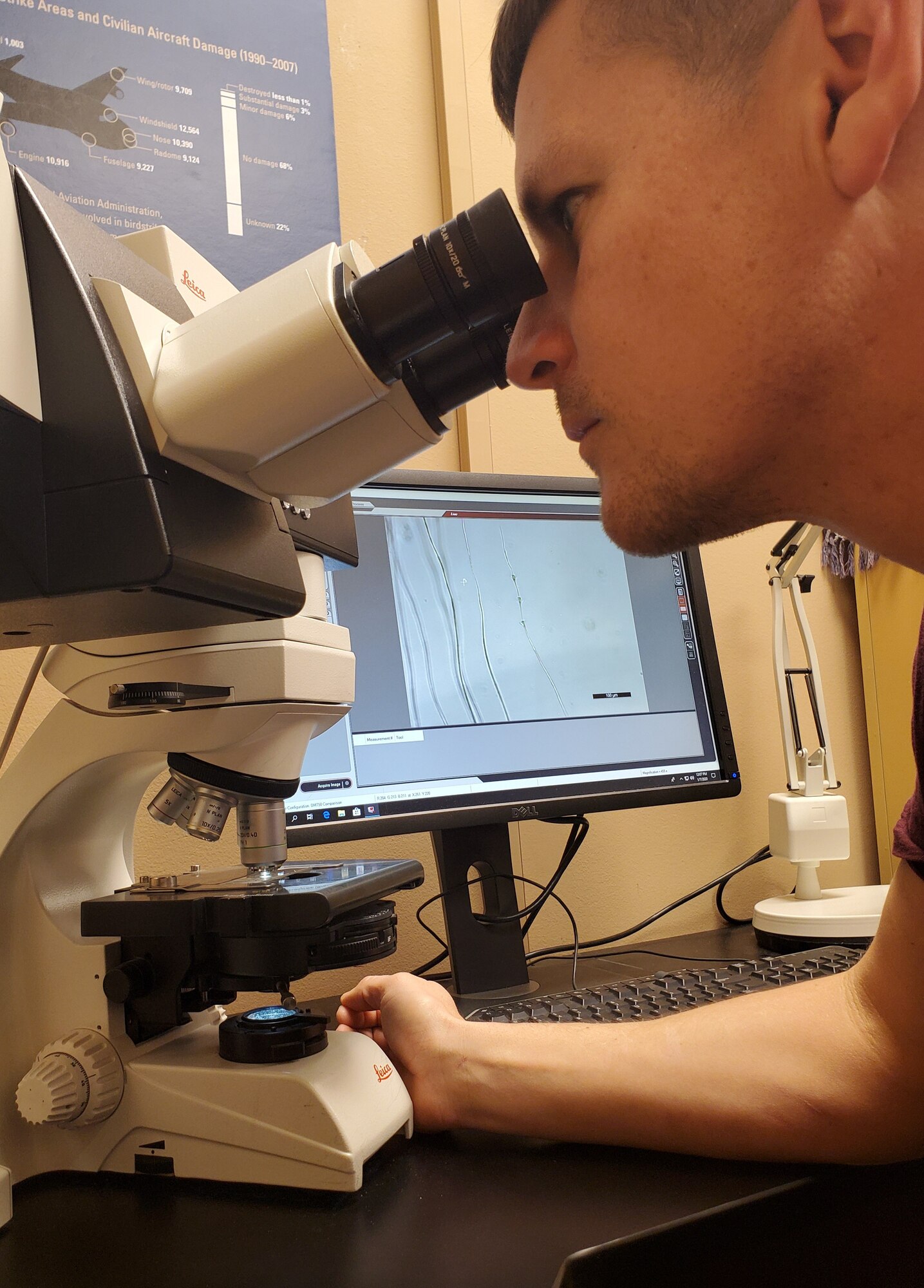 Man looking in microscope.