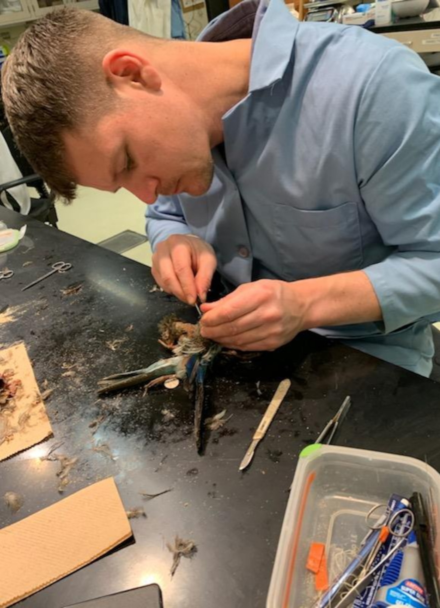 Man in lab coat with bird.