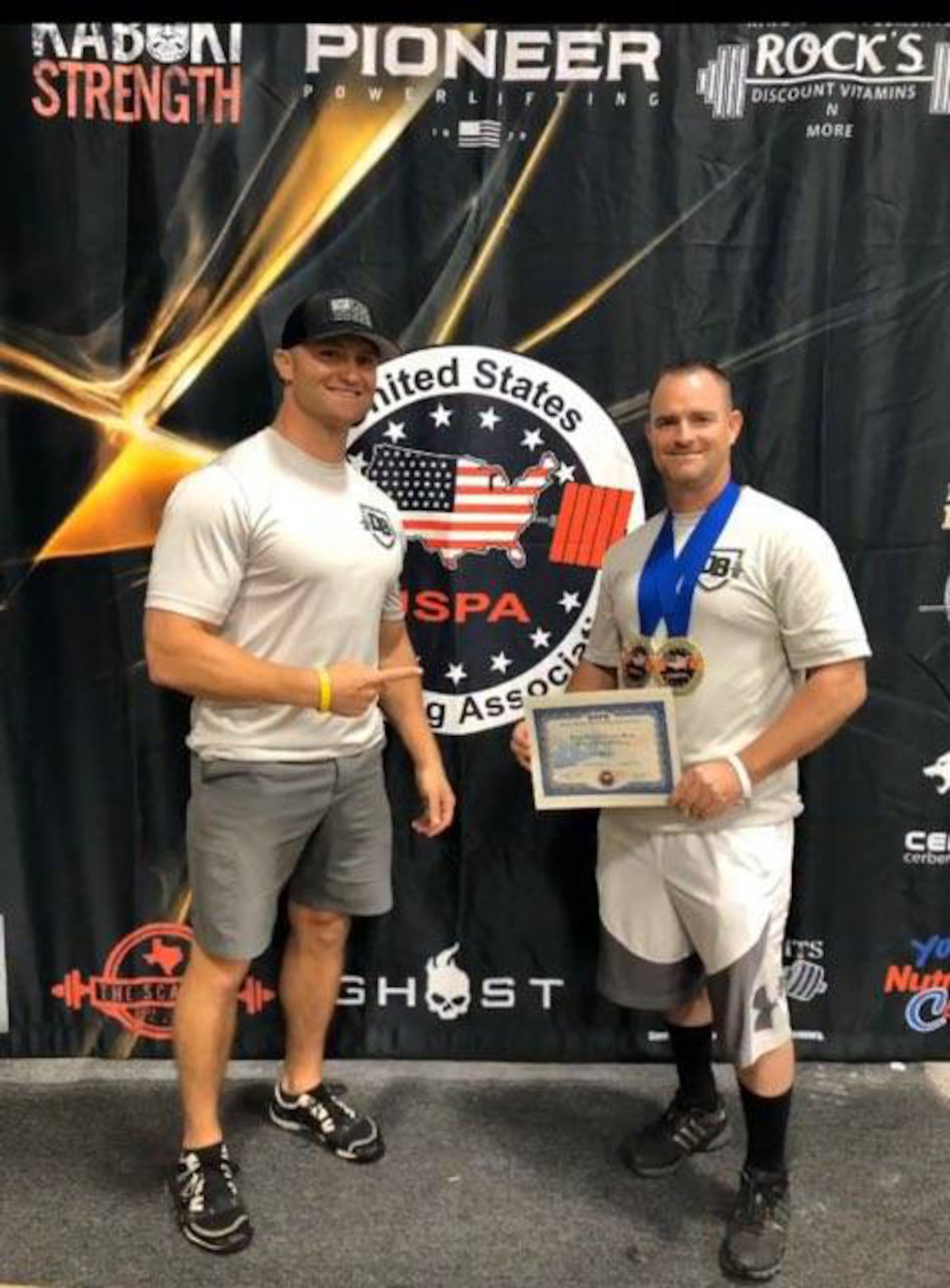 Master Sgt. Daniel Bedford (right), Air Force Recruiting Service National Events program manager and Senior Master Sgt. Michael Lear, AFRS Strategic Marketing Division superintendent, show off Bedford’s two gold medals he won at the USPA (United State Powerlifting Association) 2020 Texas State Bench Press Championship and the USPA Military National Bench Press Championship.