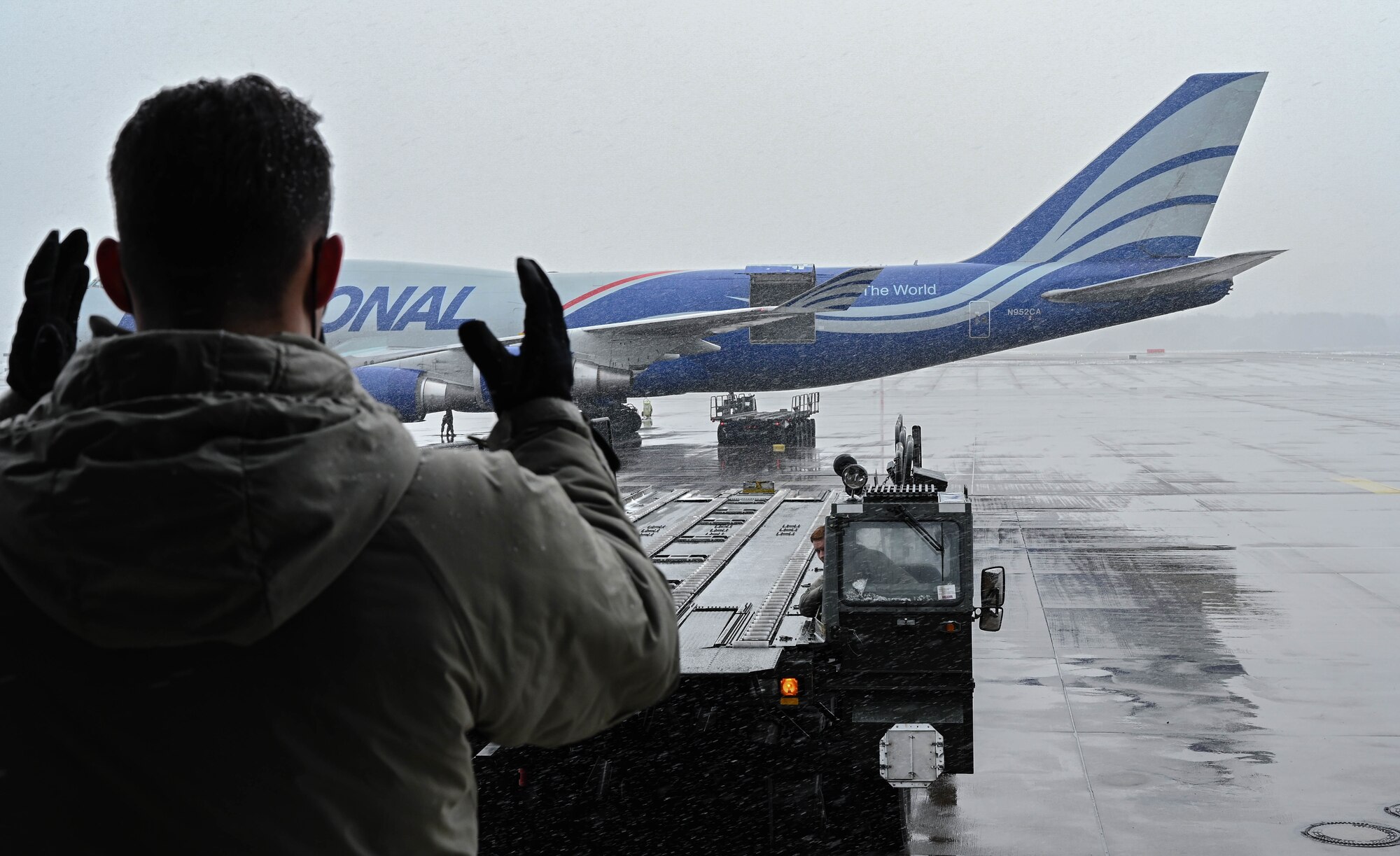 An Airman provides direction to a driver.