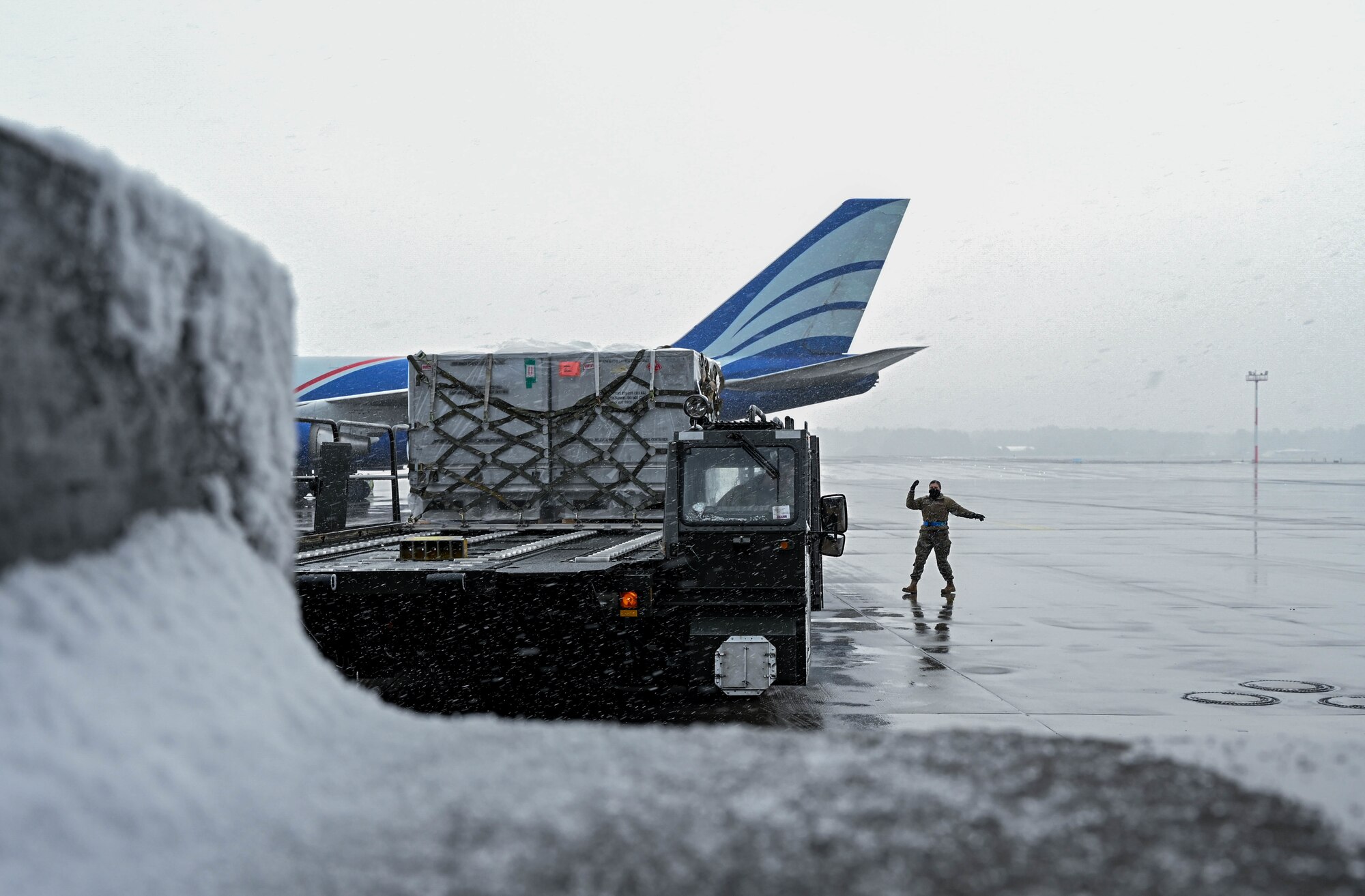 An Airman guides a driver as he backs away from a loading dock.