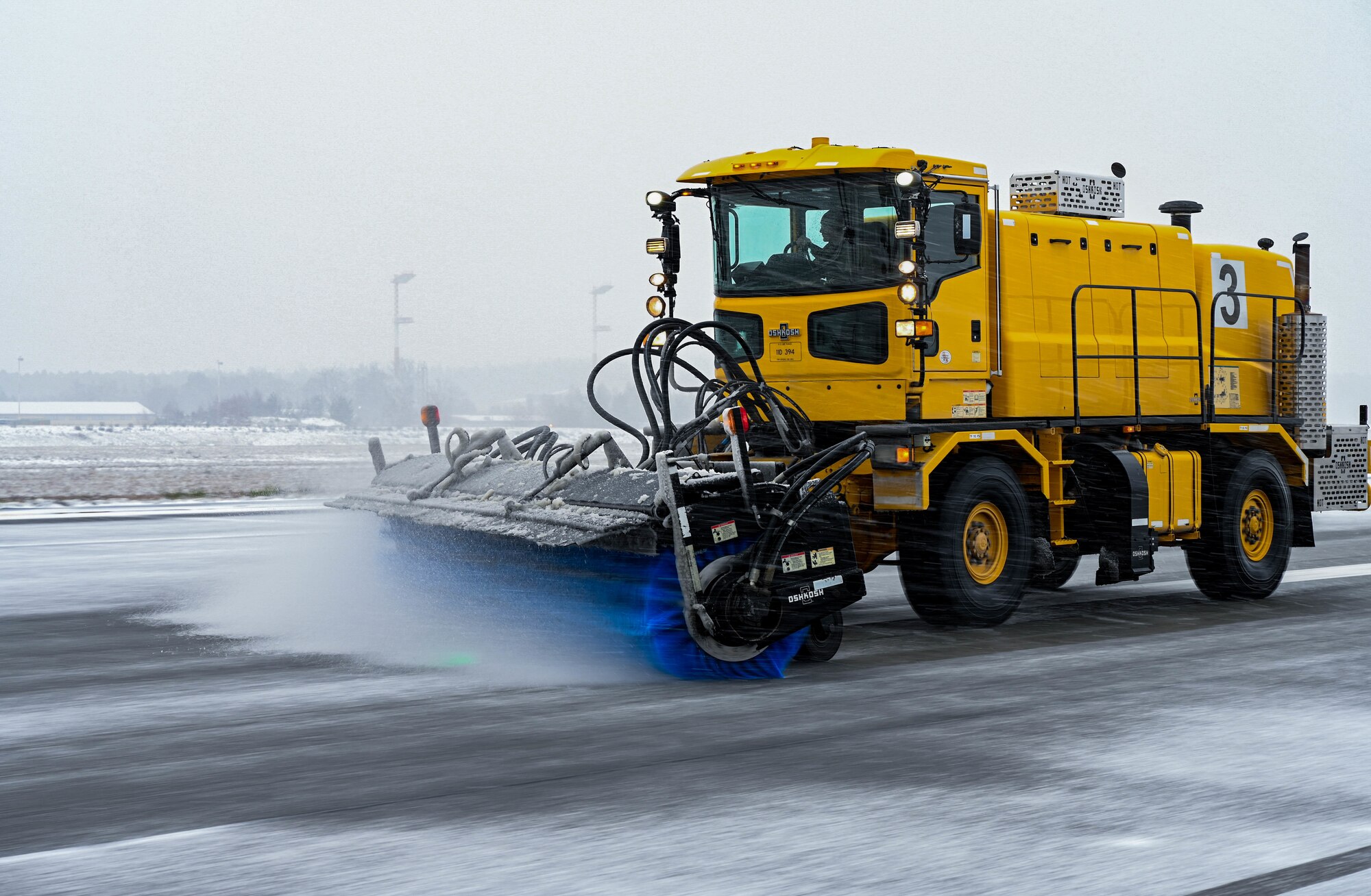 A snow plow removes snow from a flightline