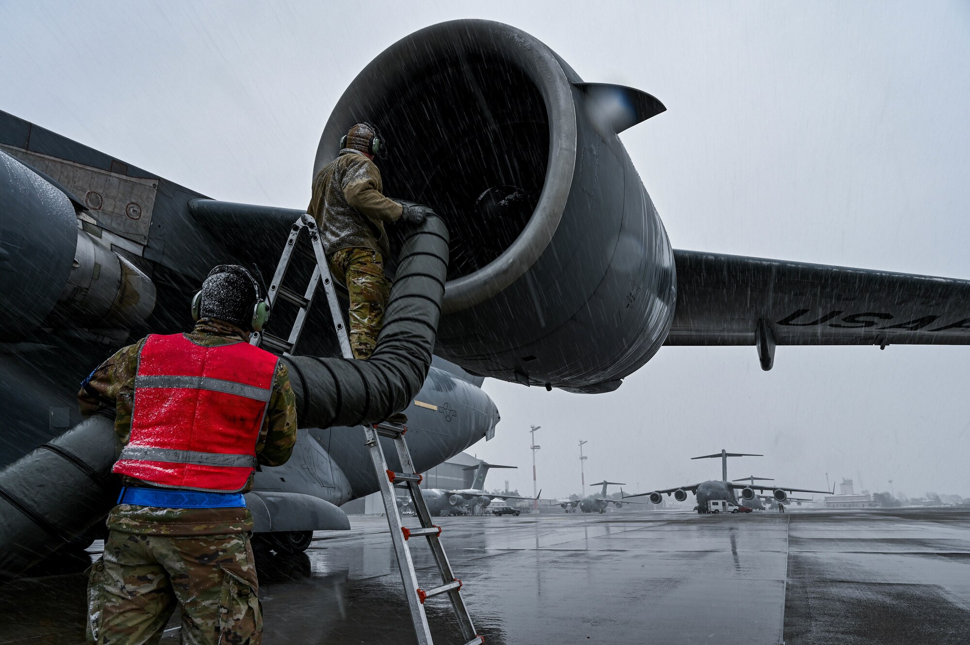 Two Airmen de-ice an aircraft.