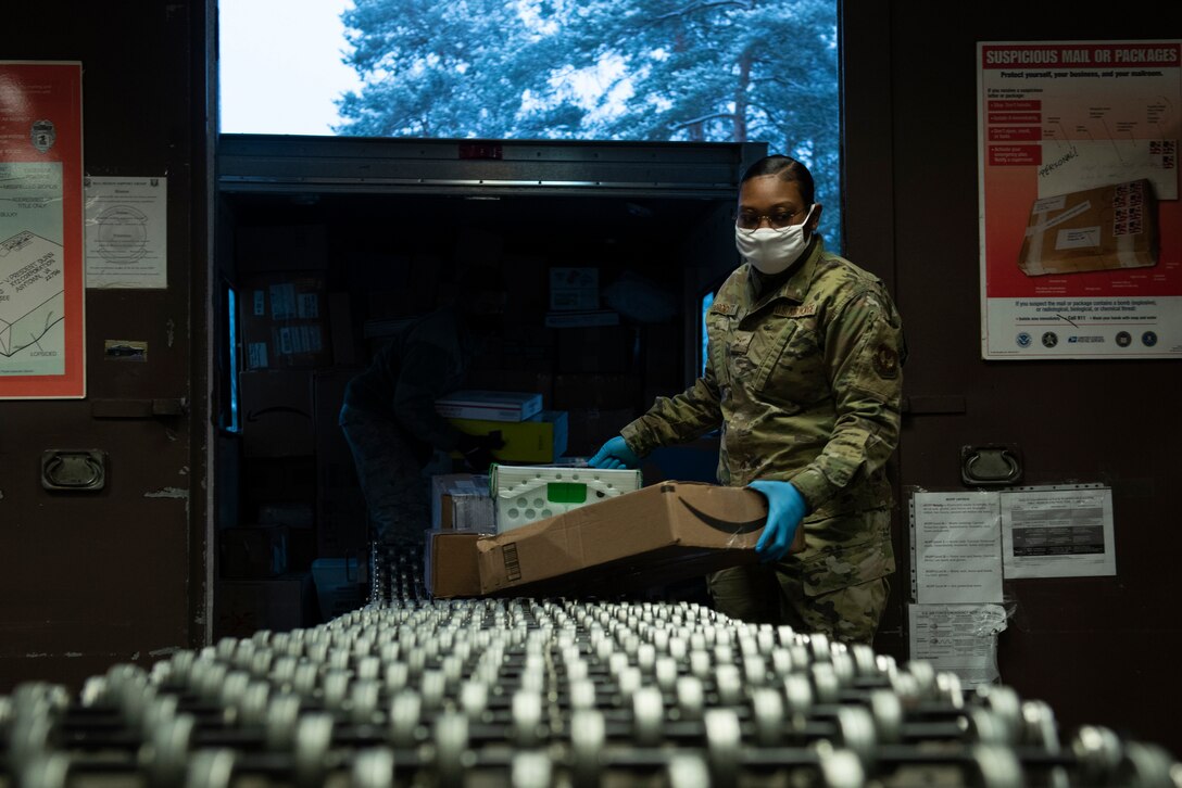 A photo of an Airman taking packages off a conveyor belt.
