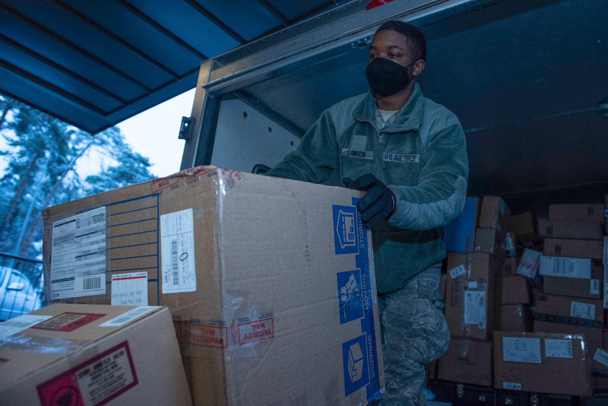 A photo of an Airman placing a package on a conveyor belt.