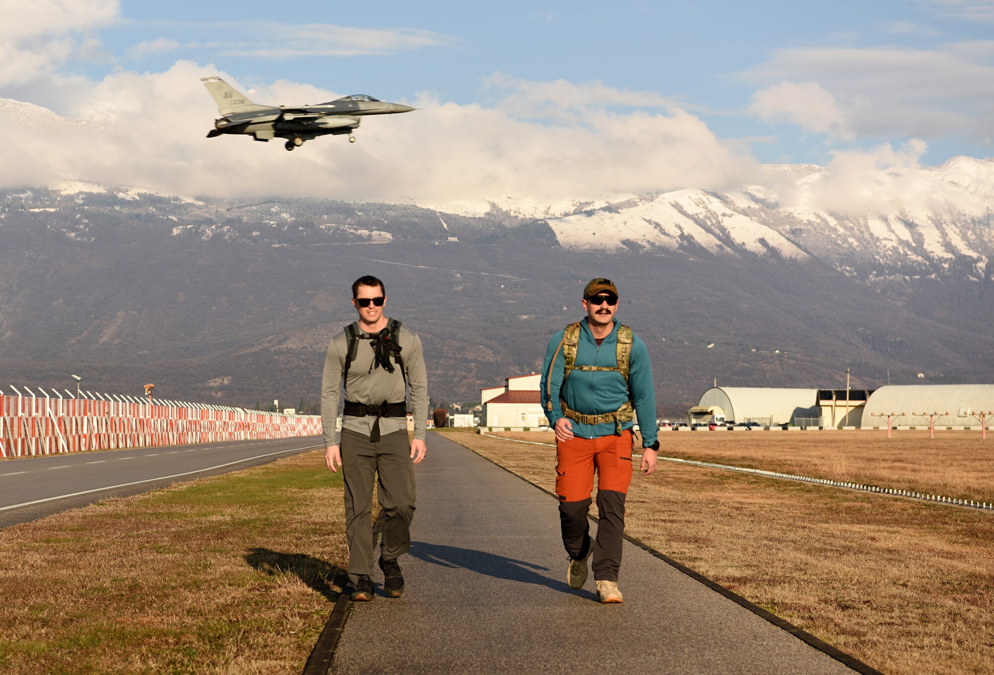 U.S. Air Force Lt. Col Bryan Ballestero, 56th Rescue Squadron assistant director of operations, left, and 1st Lt. Cody Page, 56th RQS HH-60G Pave Hawk rescue pilot, right,  participate in a ruck in memory of the fallen Jolly 22 crew at Aviano Air Base, Italy, Jan. 7, 2021.