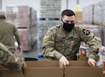 Washington National Guard Pfc. Trenton Choate packs a food box at the Emergency Food Network warehouse in Fife, Wash., on Jan. 6, 2021. The Guard helped pack more than 8,000 emergency food boxes for residents of Pierce County.