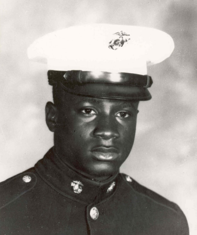 A Marine in dress uniform looks at the camera.