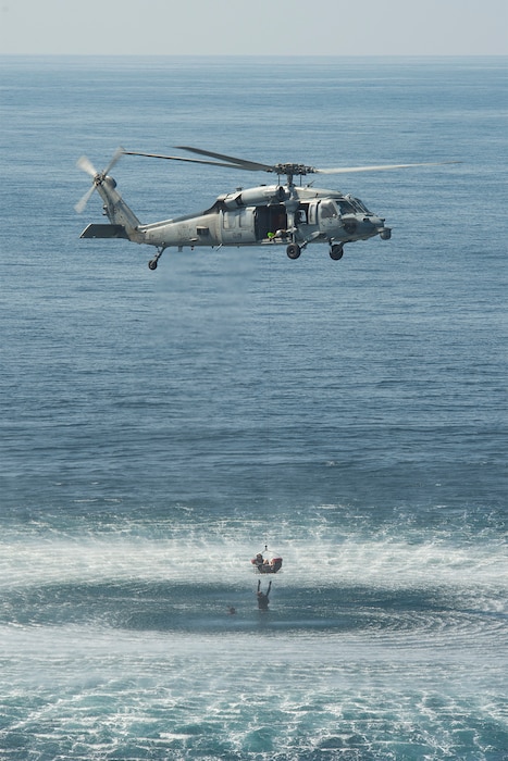 An MH-60S Sea Hawk helicopter, attached to the "Dragon Slayers" of Helicopter Sea Combat Squadron (HSC) 11, embarked to the aircraft carrier USS Harry S. Truman (CVN 75) recovers a rescue swimmer during a search and rescue exercise in the Arabian Sea Jan. 26, 2020.