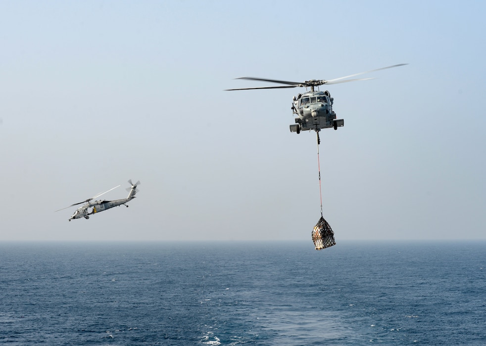wo MH-60S Sea Hawk helicopters, attached to the "Dragon Slayers" of Helicopter Sea Combat Squadron (HSC) 11, transport cargo during a replenishment-at-sea to the aircraft carrier USS Harry S. Truman (CVN 75) in the Arabian Sea Jan. 4, 2020.