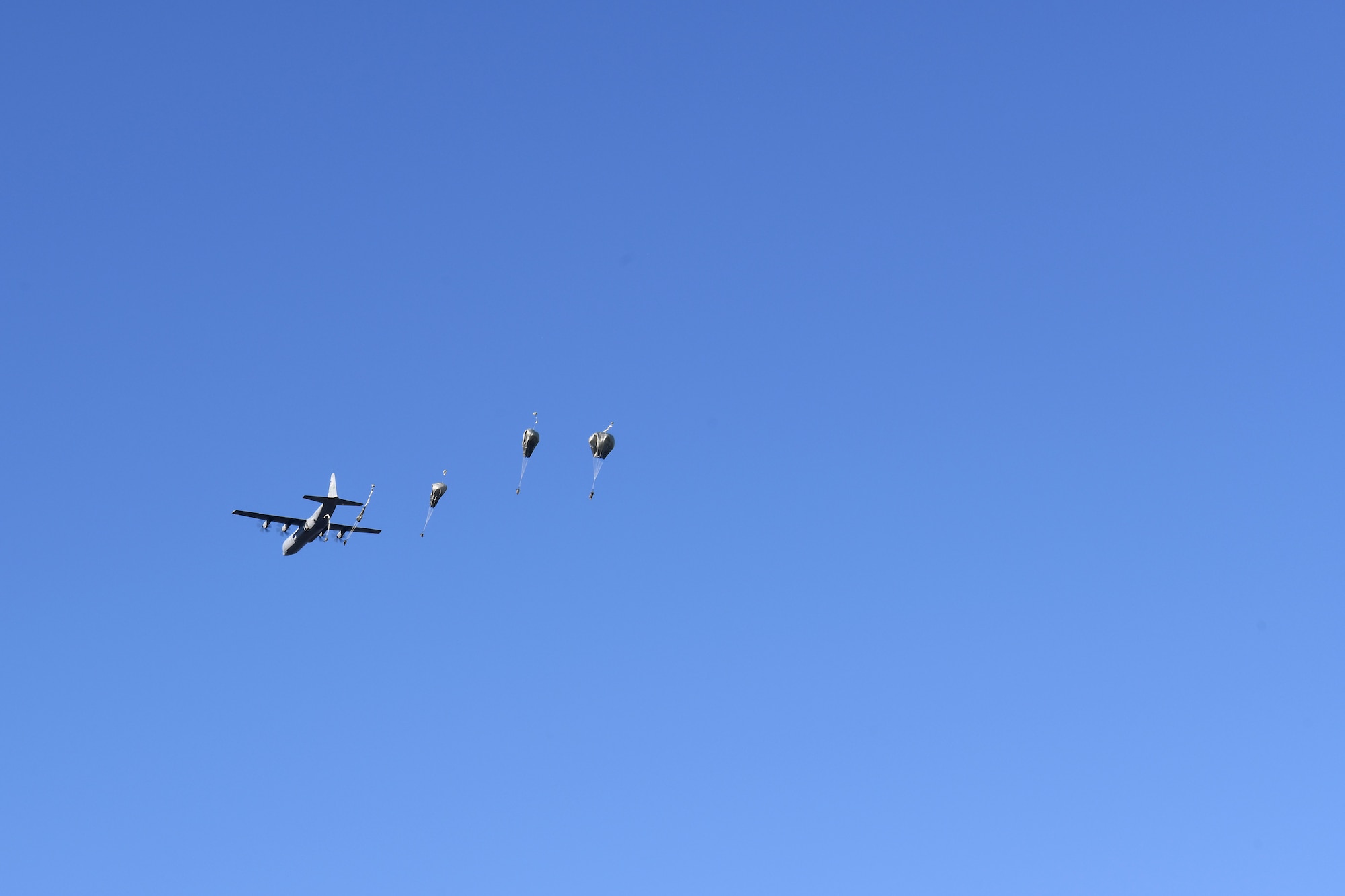 Soldiers assigned to the 346th Theater Aerial Delivery Company, an Army Airborne unit, and Marines assigned to the 3rd Brigade, 3rd Air Naval Gunfire Liaison Company, Marine Forces Reserve, jump out of a Hercules C-130 during tactical, low-level, static line parachute insertion operation training Jan. 9, 2021, at Vandenberg Air Force Base, Calif.