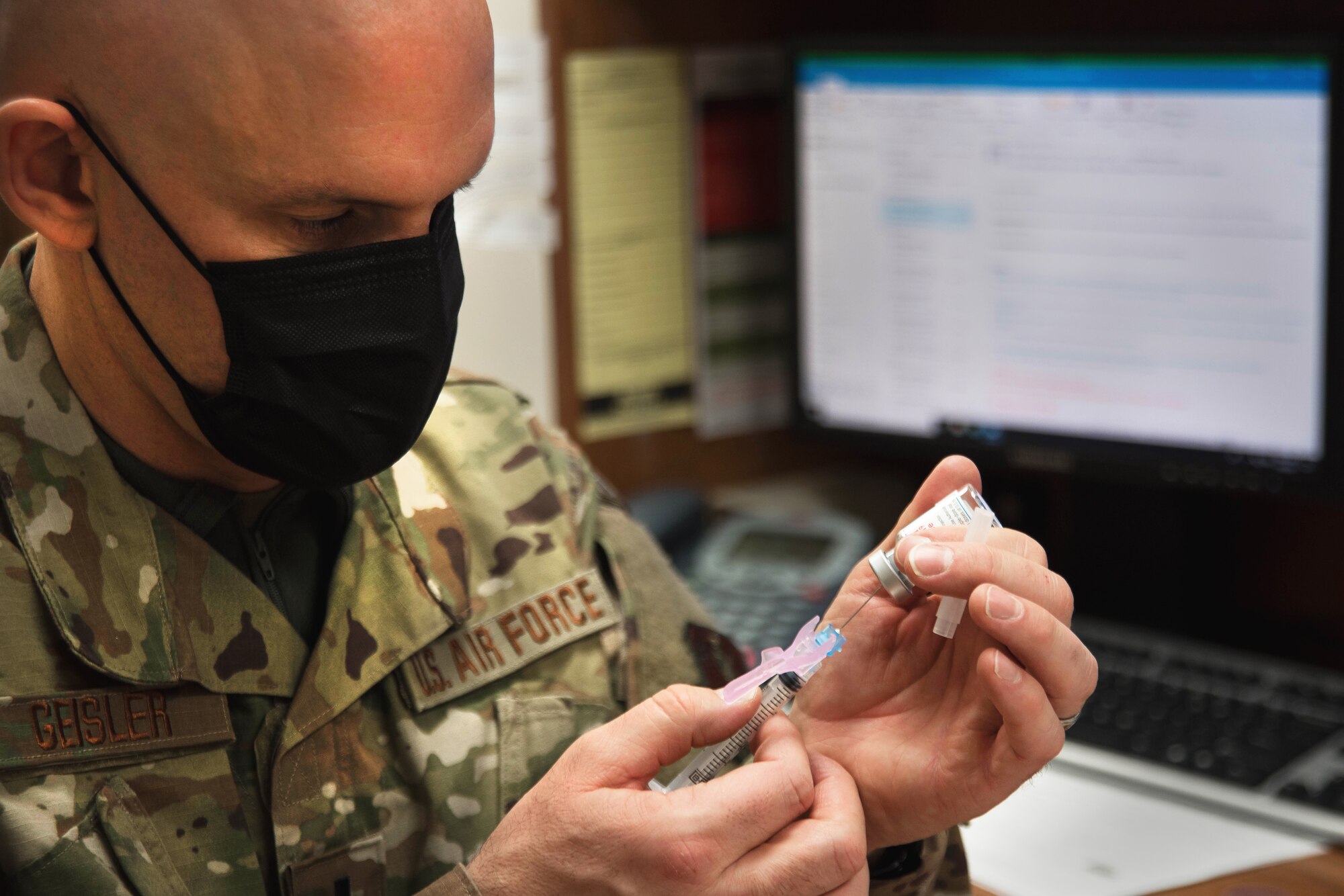 Image of an Airman holding a syringe.