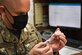 Image of an Airman holding a syringe.