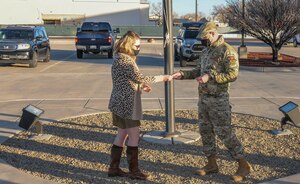 Woman receives coin from Air Force officer.