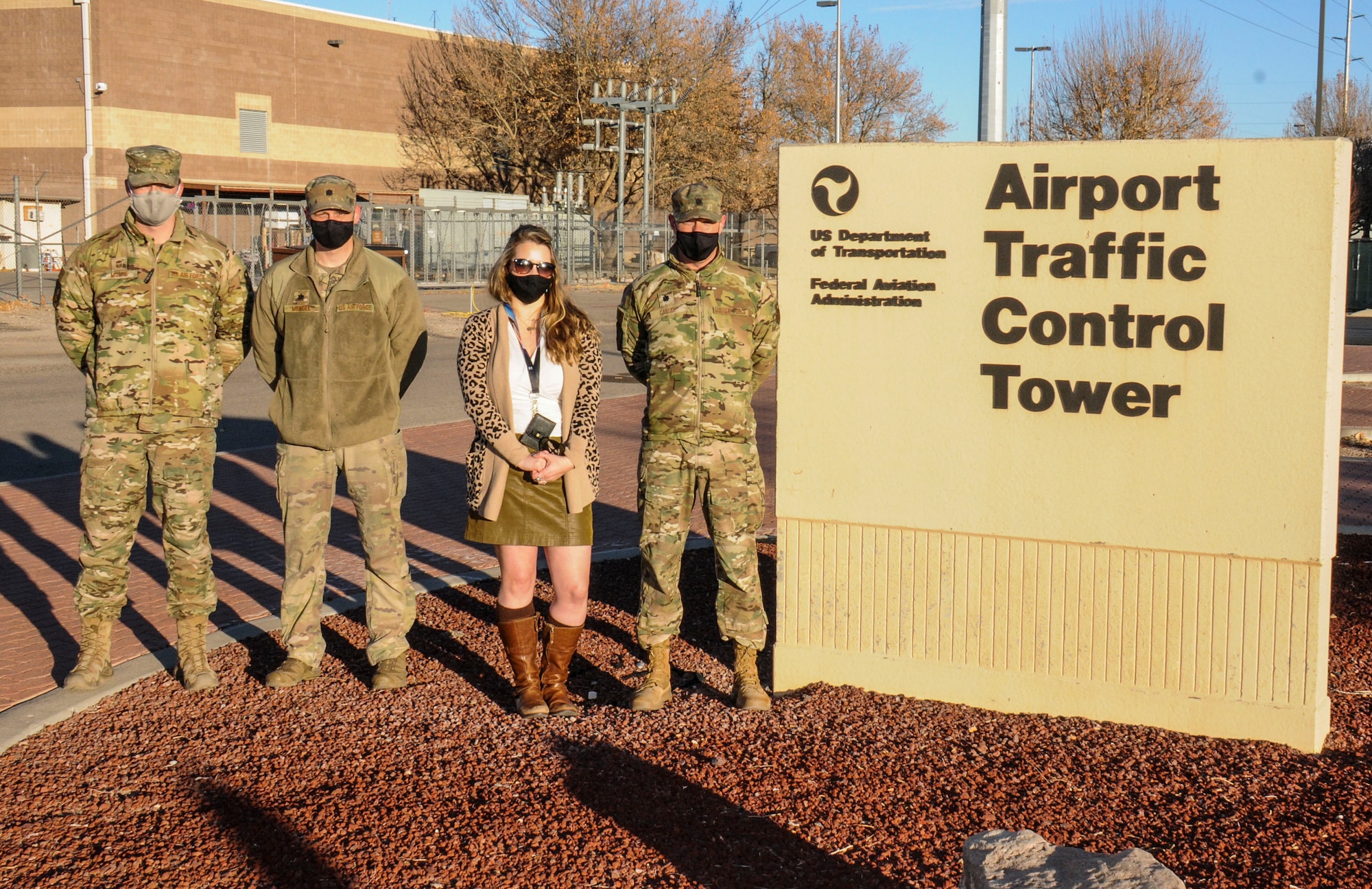 Three Airmen and a civilian woman pose for a photo at Kirtland AFB, N.M.