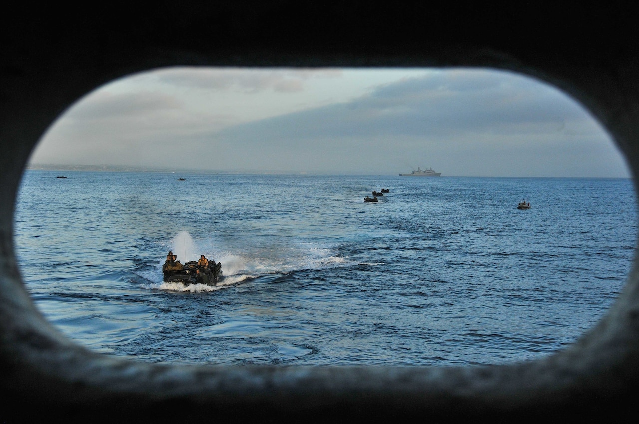 Small Navy vessels move through the water.