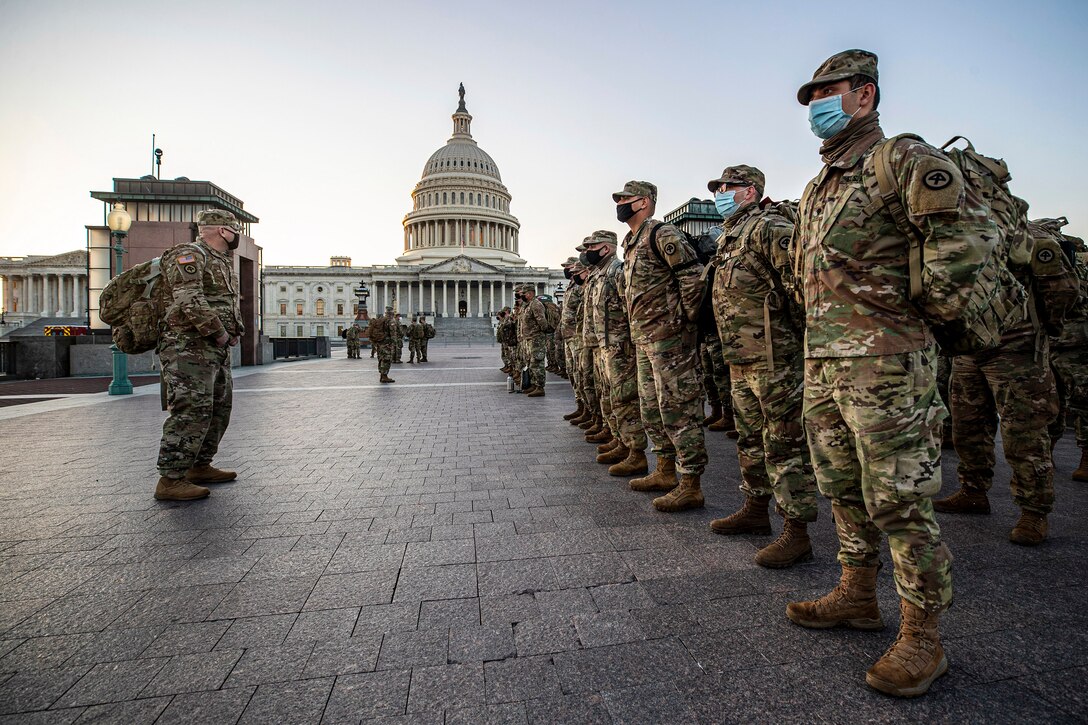 National Guard soldiers and airmen stand in formation in front of the U.S. Capitol.