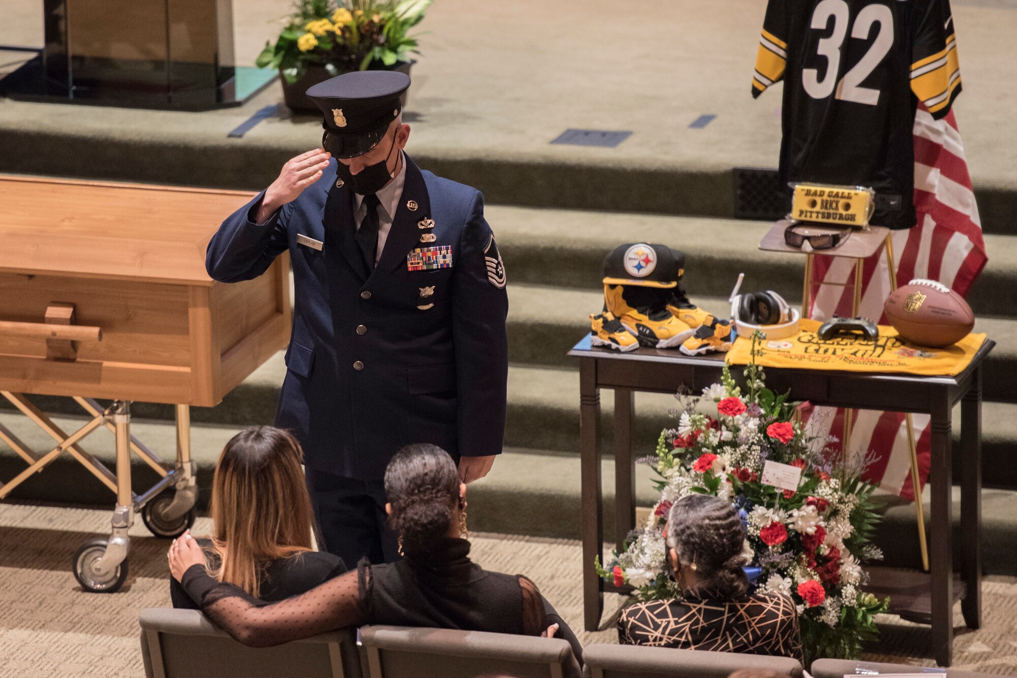 Master Sgt. Chris Taylor renders a salute after presenting a flag to London Brown, fiancee to fallen Armen and  firefighter, Senior Airman Logan Young, during funeral services at Victory Church, WInchester, Va., Jan. 7, 2021. Young died while battling an off-base barn fire Dec. 27, 2020.
