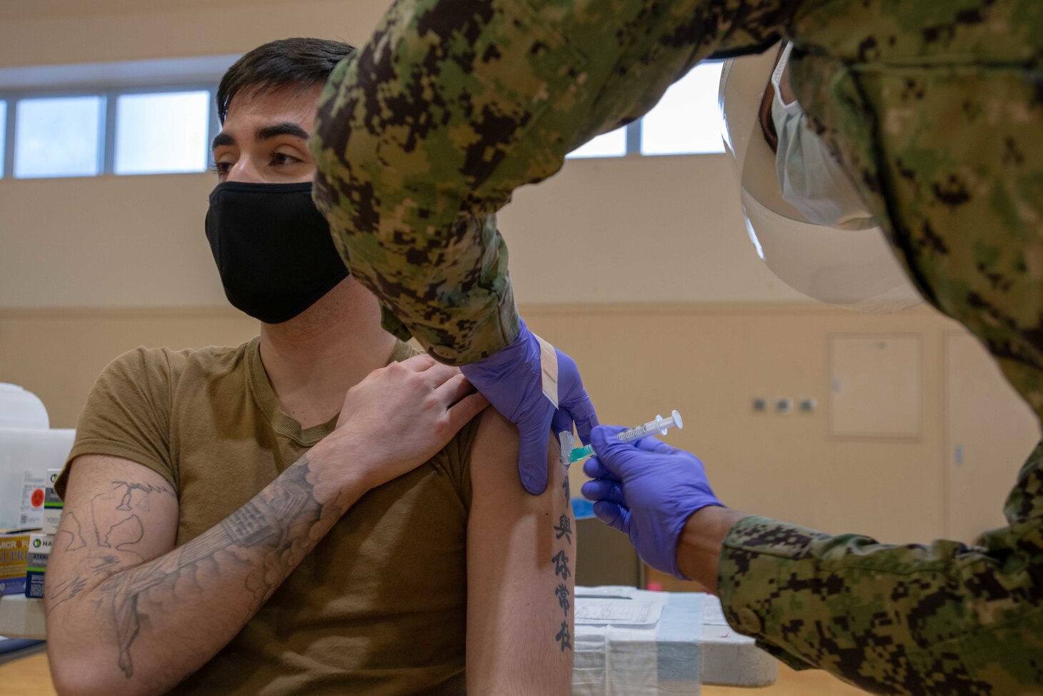 210108-N-LI114-1026 YOKOSUKA, Japan (Jan. 8, 2021) Aviation Boatswain’s Mate (Handling) Airman Joseph Caffey, assigned to the U.S. Navy’s only forward-deployed aircraft carrier USS Ronald Reagan (CVN 76), receives the COVID-19 vaccine on Commander, Fleet Activities Yokosuka (CFAY). Medical personnel and strategic forces were the first to receive the COVID-19 vaccine. Ronald Reagan returned to Yokosuka in November 2020 following a six-month deployment in the U.S. 7th Fleet area of responsibility. (U.S. Navy photo by Mass Communications Specialist 3rd Class Michael B. Jarmiolowski)