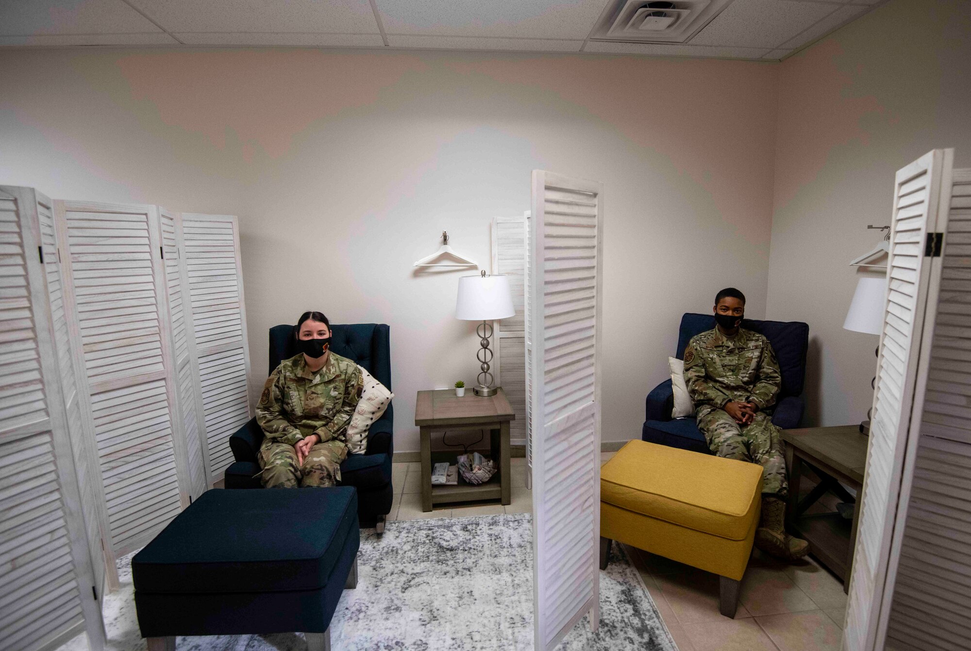 Staff Sgt. Kimberly and Staff Sgt. Laymisha, 432nd Security Forces Squadron Defenders, sit in seperate rooms seperated by a barrier to demonstrate privacy.
