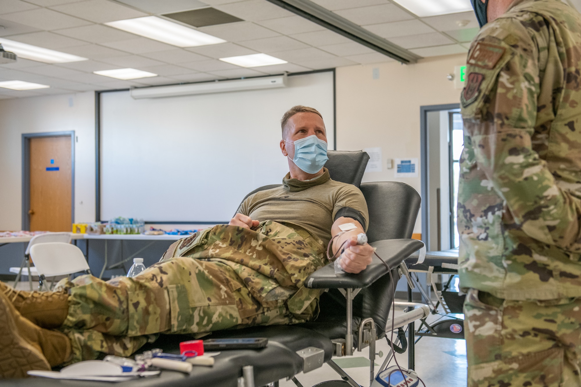 Col. Matthew Fritz, commander of the 419th Fighter Wing, speaks to Tech. Sgt. Jared Jacques, emergency management superintendent in the 419th Civil Engineer Squadron, while donating blood during the 419th FW Bloody Warrior Drive Jan. 9, 2021, at Hill Air Force Base, Utah.
