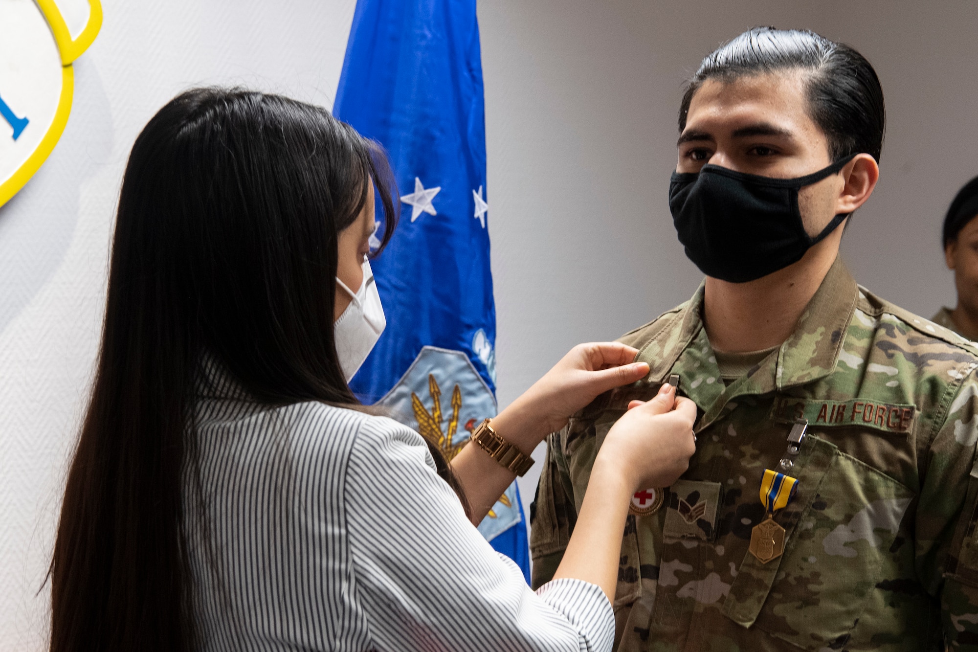 Jocelynn Cobb, Spangdahlem Red Cross regional program manager (left), presents U.S. Air Force Senior Airman Ezekiel Lopez, 52nd Force Support Squadron fitness center journeyman, with the Red Cross Certificate of Merit.