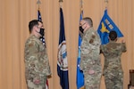 Two Airmen salute each other during a military ceremony