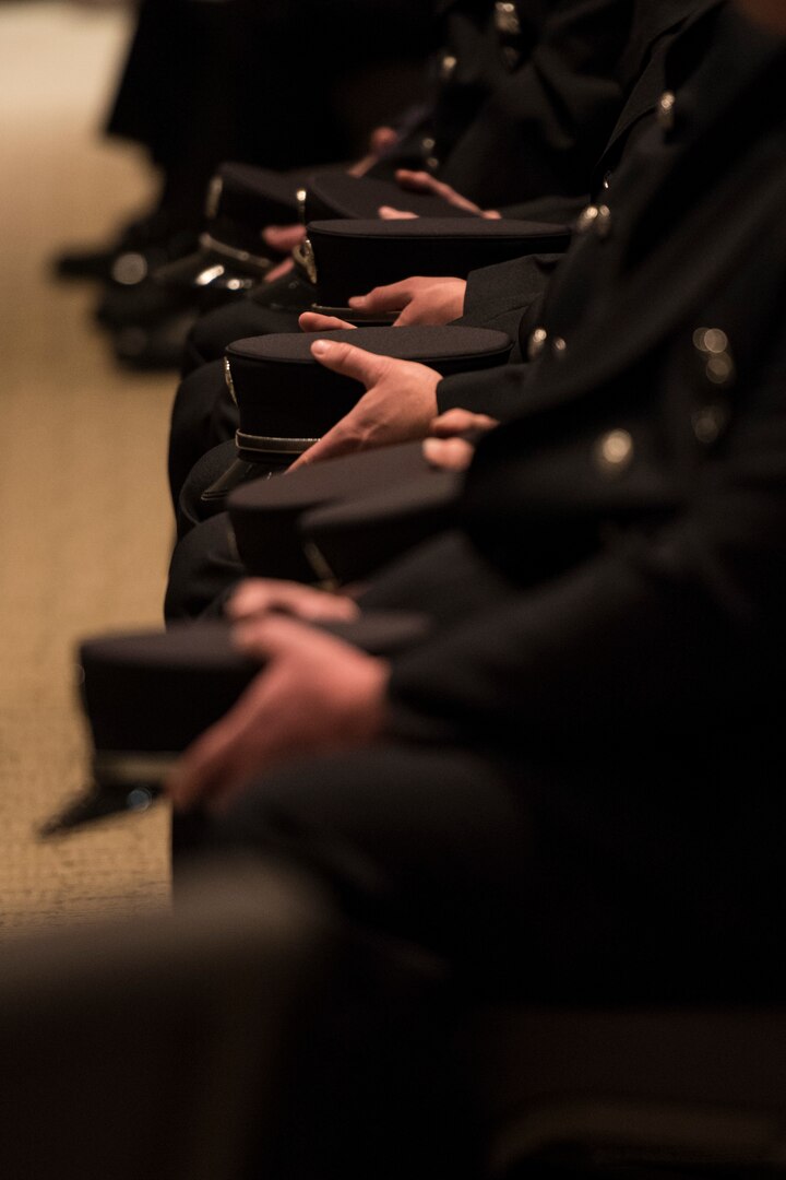 Firefighters sit holding their hats during the funeral service for Senior Airman Logan Young, a 167th Civil Engineering Squadron firefighter who died battling an off-base barn fire on Dec. 27, 2020. The funeral was held at Victory Church in Winchester, Va. Jan. 7, 2021.