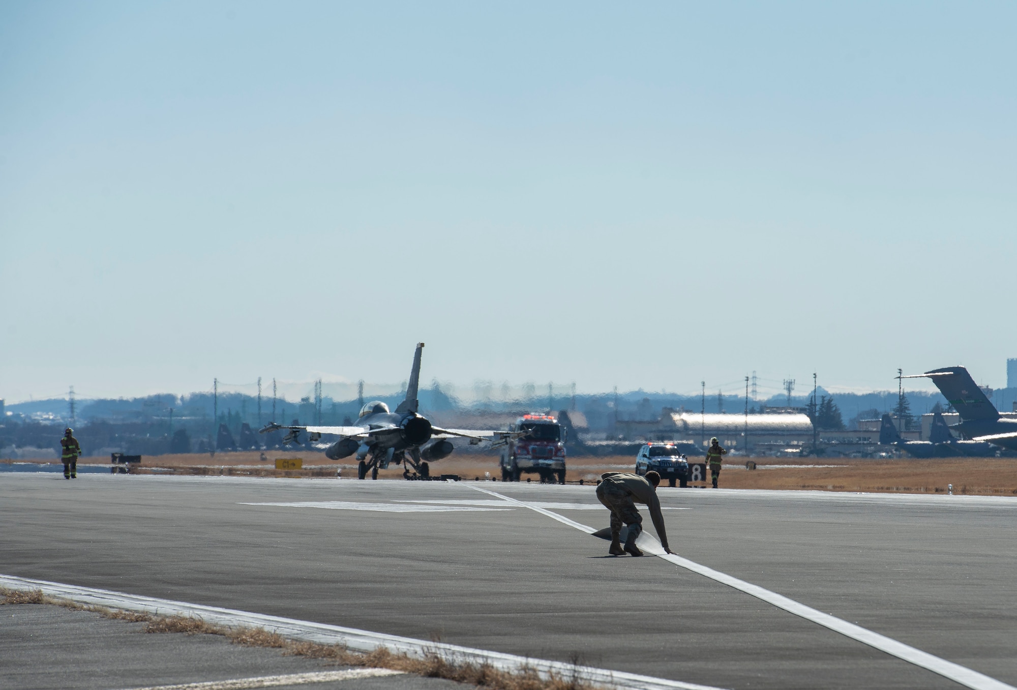 An Airman assigned to the 374th Civil Engineer Squadron checks the newly installed flightline BAK-12 barrier, aircraft arresting system (AAS) tape