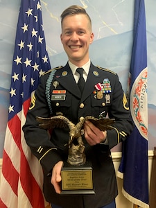 A man in uniform holds an award