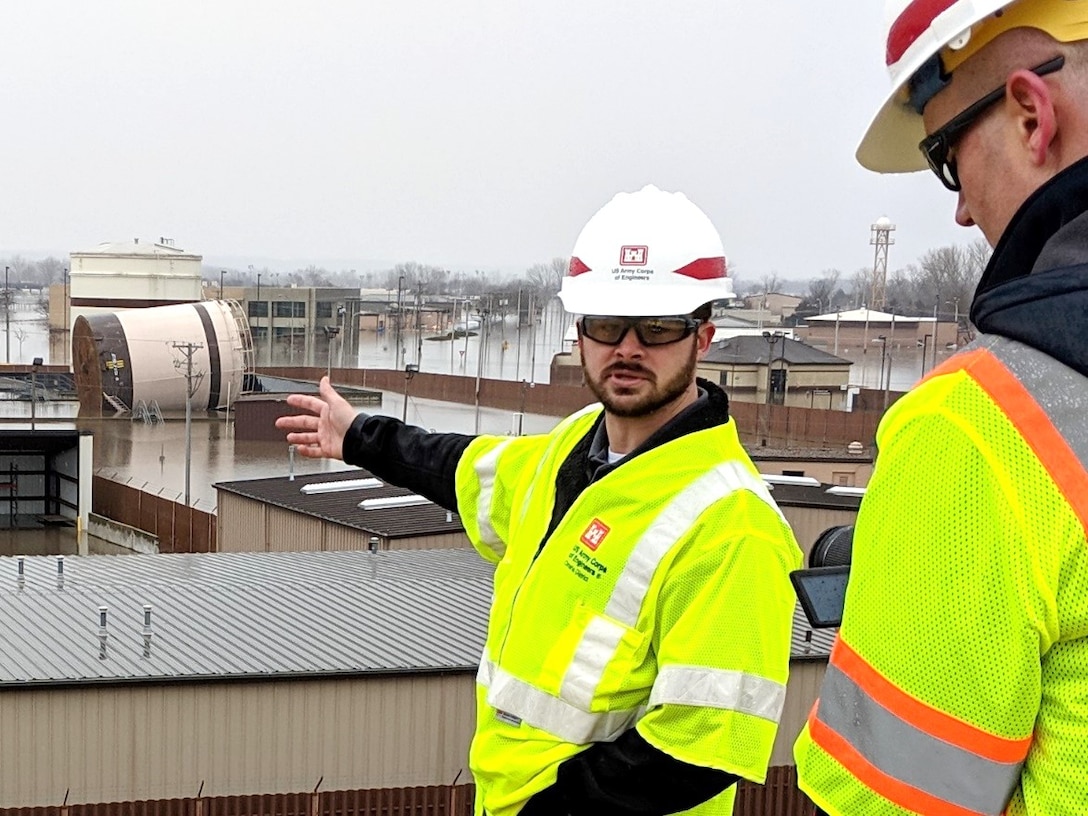 A U.S. Army Corps of Engineers structural engineer points to a tank laying on its side